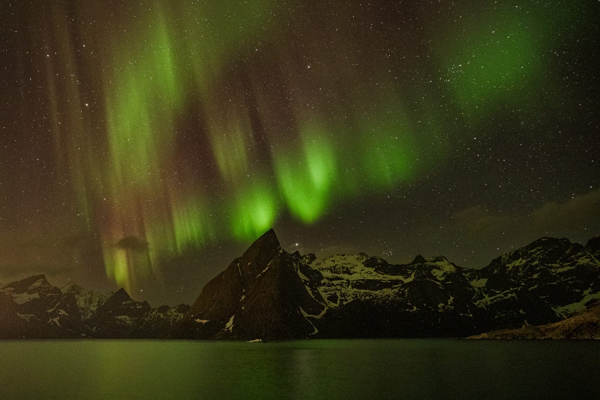 Ribbons of green and red light dance over the Lofoten Islands in Norway