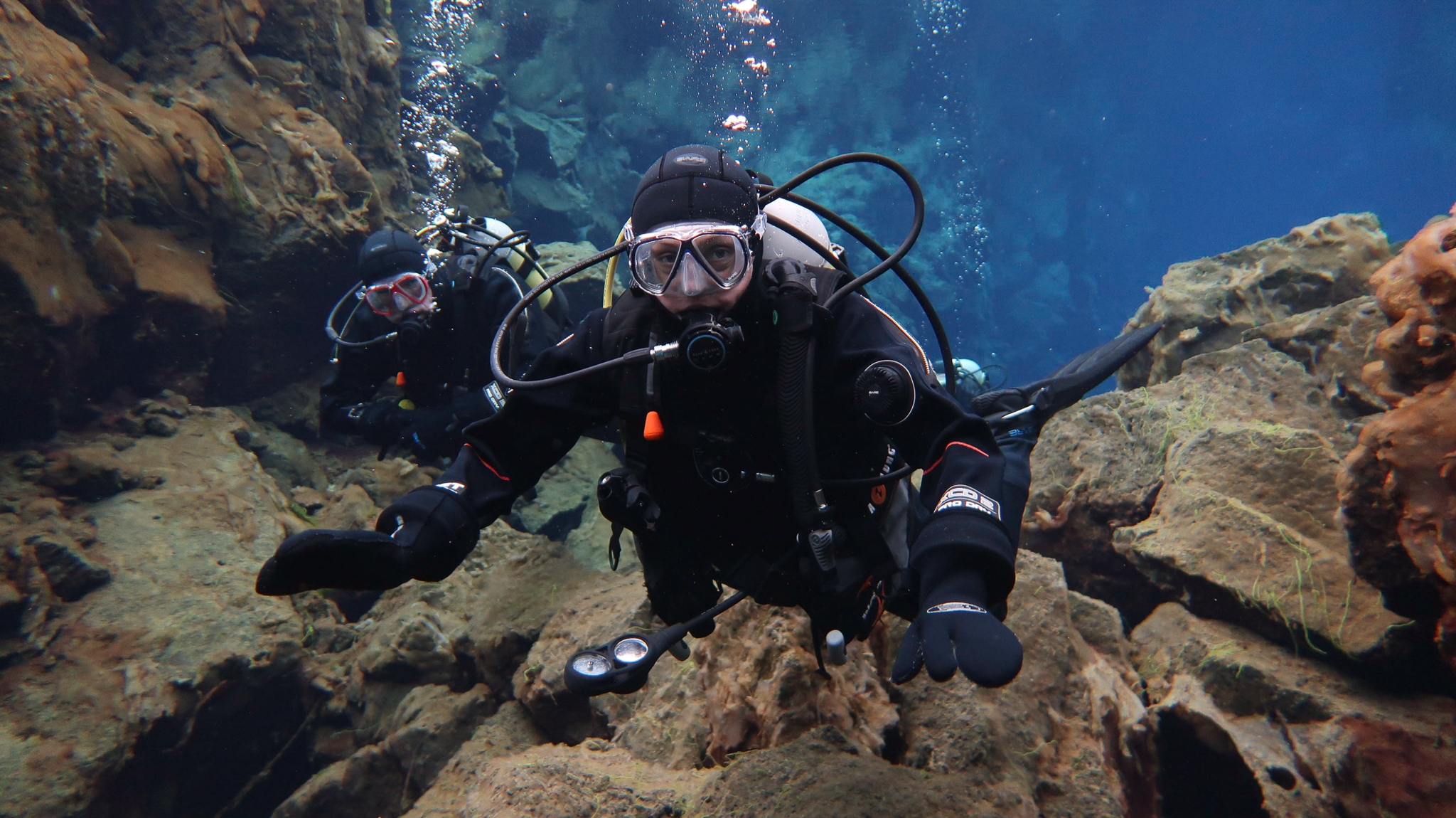 Des and Belinda scuba diving at Silfra Fissure in Thingvellir National Park, Iceland. Photo by Tania Roque of DIVE.IS